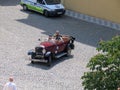 Sightseers make trip at old town by vintage open car