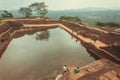 People relaxing around ancient pond of Sigiriya city with ruins and archeological area Royalty Free Stock Photo