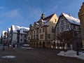 Historic town hall with yellow painted facade located at a square in pedestrian zone in city center.