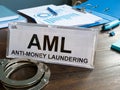 Sign AML anti money laundering and handcuffs on the desk.
