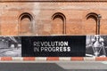 Sign in an area undergoing regeneration reads, 'Revolution in Progress in Manchester, UK