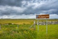 Sign for Arnol Black House in Gaelic with beautiful Scottish landscape in the background Royalty Free Stock Photo