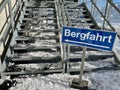 Sign Ascent (Bergfahrt) in front of iron stairs at ski lift in Austrian Alps.