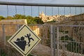 Sign attached to metal fence at Fort Manoel in Malta warning of the dangers of falling. The dome of St Paul`s church in Valletta Royalty Free Stock Photo