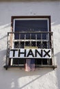 Sign banner from window saying thanks to health care workers. THANX hanging with USA flag.