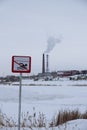 Sign Bathing is prohibited on background of factory in winter. Royalty Free Stock Photo