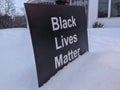 Sign black lives matter in the snow in front of the building. Selective focus.