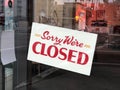 A Sign board of sorry we are closed hang on door of business shop with nature green background Royalty Free Stock Photo