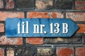 A sign on a brick wall, with the inscription of the Till Nr. 13B. Pointers.