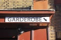 Sign on brick wall at a restaurant showing direction to the wardrobe Dutch/German: Garderobe Royalty Free Stock Photo