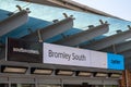 Sign for Bromley South Railway Station showing the Southeastern logo and Oyster logo