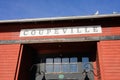 Sign for the city of Coupeville on red building with blue sky