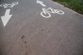 Sign cyclist and the direction arrow on the background of asphalt road Royalty Free Stock Photo