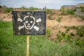 Sign of danger announcing about mined fields in front of green gras