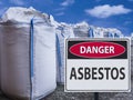 Sign danger asbestos and a stack of big bags of asbestos. Royalty Free Stock Photo