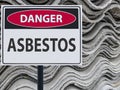 Sign danger asbestos and a stack of sheets roof of asbestos.