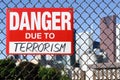 Sign danger due to terrorism hanging on the fence Royalty Free Stock Photo