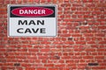 Sign danger man cave on red brick wal Royalty Free Stock Photo