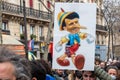 Sign depicting President Macron as Pinocchio during a protest in Paris, France