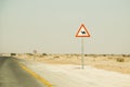 Road sign caution camels crossing. Beware of camels on desert highway. Royalty Free Stock Photo