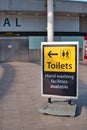 A sign at the deserted South Terminal of Gatwick Airport points the way to toilets and hand washing facilities Royalty Free Stock Photo