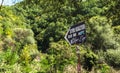 Sign directing to the Blue Eye spring on the background of the green trees