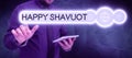 Sign displaying Happy Shavuot. Word for Jewish holiday commemorating of the revelation of the Ten Commandments