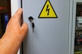 The sign on the door gently with electricity and hand in glove dielectric opens the door