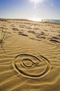 At sign drawn in the sand on the beach