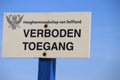 Sign with dutch text Verboden toegang which means in English no admittance of the water authority Delfland in the dunes of Monster