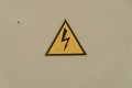 Sign electrical hazard placed on a rusty metal panel.