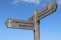 A sign on the England coastal path pointing the direction of Donniford and East Quantoxhead. Low level shot with a blue sky and a