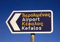 A sign in English and Greek directing tourists to The Airport