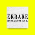 Sign Errare humanum est. To err is human. White wooden wall, boards. Old white rustic wood background, wooden surface