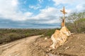 A sign of faith, a cross, beautiful clouds in a dry road at Cariri Paraiba Brazil Countryside