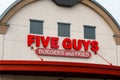 Sign on Five Guys burger and fries restaurant above red awning