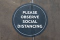 A sign on the floor asking people to observe social distancing rules