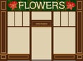 A sign of a flower shop. Brown facade and shop windows