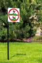A sign forbidding people and dogs to walk on a green lawn