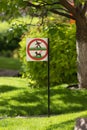 A sign forbidding people and dogs to walk on a green lawn