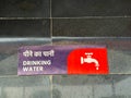 A sign in a foreign language with a red and white water tap on it Royalty Free Stock Photo