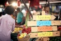 Sign for fresh and organic vegetables  at the green market or farmers market stall.  Young buyers choose and buy products for Royalty Free Stock Photo