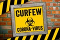 Sign in front of a clinker wall with curfew and corona virus Royalty Free Stock Photo