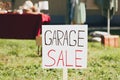 Sign Garage sale written on cardboard in yard, closeup Royalty Free Stock Photo