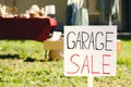 Sign Garage sale written on cardboard in yard, closeup. Space for text Royalty Free Stock Photo