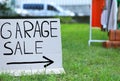 Sign Garage sale written on cardboard in yard. Space for text Royalty Free Stock Photo