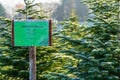 Sign with German lettering `Christmas trees sale` in front of frost covered evergreen fir trees on a Christmas tree farm Royalty Free Stock Photo