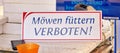 Sign in German words MÃÂ¶wen fÃÂ¼ttern verboten means please do not feed the seagulls Royalty Free Stock Photo