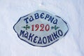 Sign of greek tavern on a white wall