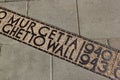 Sign on the ground where the wall of the Jewish Warsaw ghetto was located during the Second World War